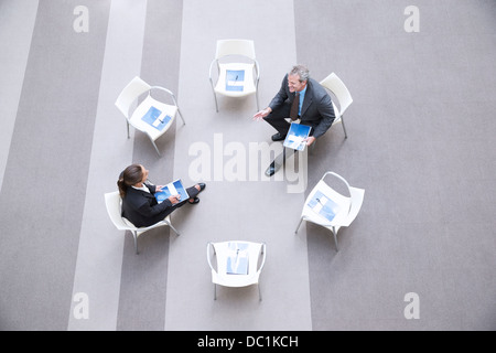 Erhöhte Ansicht der Geschäftsmann und Geschäftsfrau sprechen auf Stühlen im Kreis Stockfoto