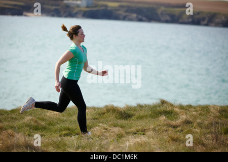 Junge Frau in der Nähe Küste läuft Stockfoto