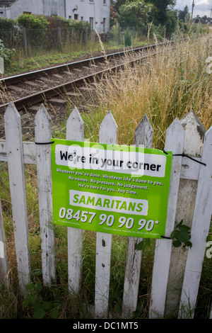 Ein Samariter melden Sie emotionale Unterstützung und Sicherheit für die Prüfung von Selbstmord bei einem unbemannten Bahnübergang in Reedham auf den Norfolk Broads. Isolierte Eisenbahnlinien wie dies im Vereinigten Königreich sind oft Orte wo die verzweifelte machen schwere Entscheidungen über ihr Leben und die Samariter ihre Anwesenheit bekannt machen indem man Schilder mit den dazugehörigen Telefonnummern als Abschreckung in dieser ländlichen Ecke der britischen East Anglia, bekannt für seine flachen Fenland Landschaft, weiten Himmel und kleinen Gemeinden genannt. Stockfoto