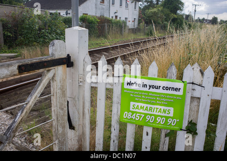 Ein Samariter melden Sie emotionale Unterstützung und Sicherheit für die Prüfung von Selbstmord bei einem unbemannten Bahnübergang in Reedham auf den Norfolk Broads. Isolierte Eisenbahnlinien wie dies im Vereinigten Königreich sind oft Orte wo die verzweifelte machen schwere Entscheidungen über ihr Leben und die Samariter ihre Anwesenheit bekannt machen indem man Schilder mit den dazugehörigen Telefonnummern als Abschreckung in dieser ländlichen Ecke der britischen East Anglia, bekannt für seine flachen Fenland Landschaft, weiten Himmel und kleinen Gemeinden genannt. Stockfoto