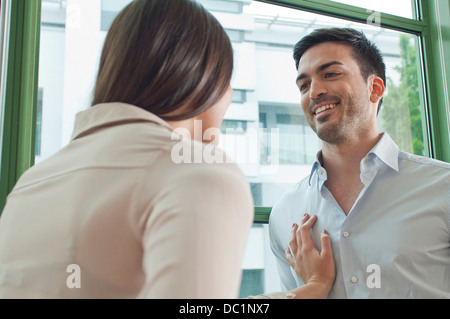 Junge Kolleginnen und Kollegen im Büro flirten Stockfoto