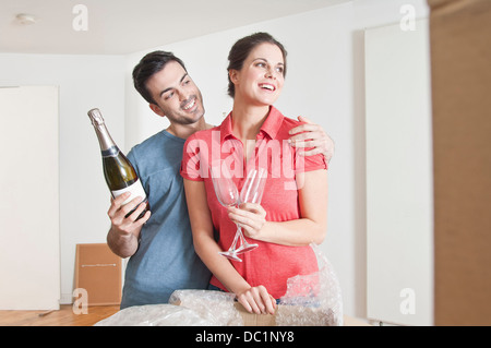 Junges Paar feiert Haus bewegen sich mit Champagner Stockfoto