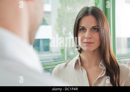 Junge weibliche Büroangestellte Angesicht zu Angesicht mit männlichen Kollegen Stockfoto