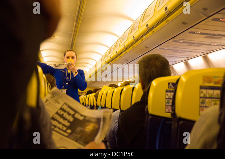 Demonstration der Sicherheit an Bord eines Ryanair-Flugs ignorieren einige Passagiere die Informationen weiter lesen Zeitung Stockfoto