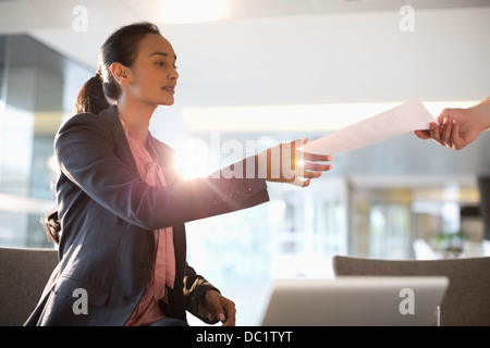 Geschäftsfrau für Papierkram zu erreichen Stockfoto