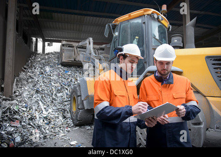 Arbeitnehmer, die Überprüfung clip Chart auf Schrottplatz Metall Stockfoto