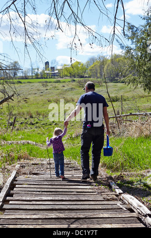 Vater und Tochter Hand in Hand und zu Fuß über die Holzbrücke Stockfoto