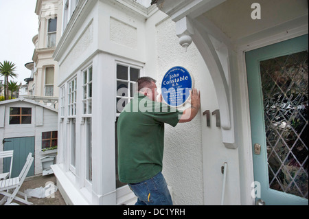 Ein Erbe Plaque-Installer behebt eine blaue Plakette an der Seite eines Hauses, wo John Constable in Brighton lebte. Stockfoto