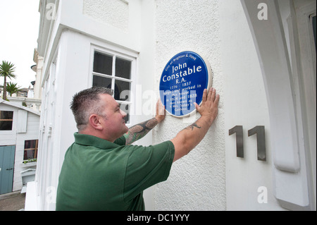 Ein Erbe Plaque-Installer behebt eine blaue Plakette an der Seite eines Hauses, wo John Constable in Brighton lebte. Stockfoto