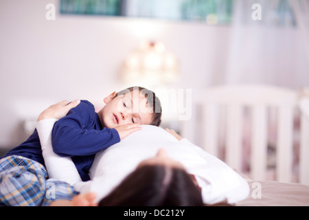 Kleiner Junge still ruht auf seine Mütter Beule Stockfoto