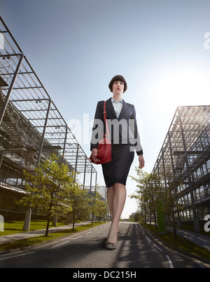 Übergroße Geschäftsfrau, die zu Fuß unterwegs, niedrigen Winkel Ansicht Stockfoto