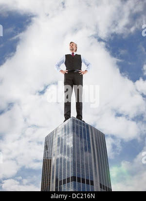 Übergroße Geschäftsmann auf Wolkenkratzer, niedrigen Winkel Ansicht stehen Stockfoto
