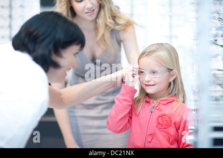 Optiker guiding junges Mädchen auf Wahl der Brille Stockfoto