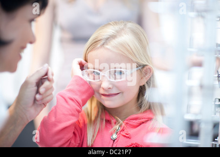 Junge Mädchen bei der Wahl der Brille Stockfoto