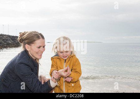 Mutter und Kleinkind an Küste erkunden Stockfoto