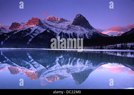 Mount Lawrence Grassi und Ha-Ling peak bei Sonnenaufgang und spiegelt sich in den Stausee oberhalb der Stadt Canmore. Stockfoto