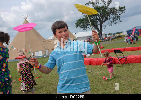 Denbigh, Clwyd, Wales UK. Mittwoch, 7. August 2013. Ein Junge jonglieren Platten an einen Zirkus-Workshop bei der 2013 National Eisteddfod von Wales The National Eisteddfod ist ein jährliches Festival feiert das Beste aus Wales, die jedes Jahr in der ersten Augustwoche stattfindet. Das Highlight der walisischen Sprache Kulturkalender vereint Glastonbury mit den Edinburgh Festivals. Er findet an einem anderen Ort jedes Jahr abwechselnd in Nord- und Süd-Wales und begrüßt mehr als 150 000 Besucher im Laufe der Veranstaltung. Bildnachweis: Keith Morris/Alamy Live-Nachrichten Stockfoto