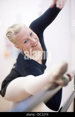 Weibliche Ballerina erstreckt sich auf die barre Stockfoto