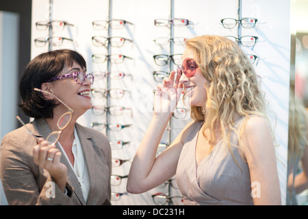 Zwei Frauen, die versuchen auf Brillen in Optiker-shop Stockfoto
