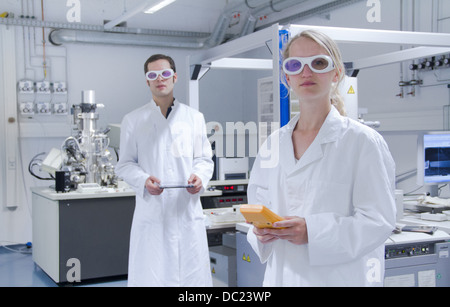 Zwei Wissenschaftler tragen Kittel und Schutzbrille im Labor stehen Stockfoto
