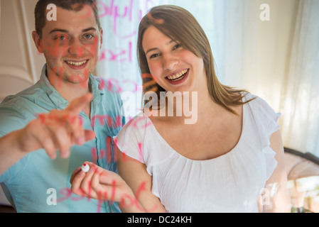 Paar schreiben Namensliste auf Glas Stockfoto