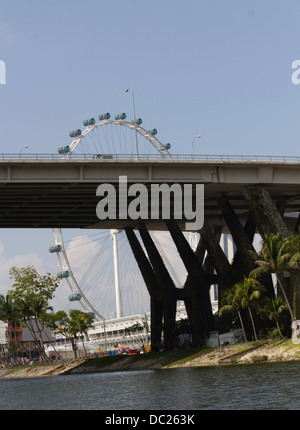 Spannweite der Benjamin Sheares Bridge mit den Säulen in Singapur und das Rad der Singapore Flyer. Wasserbehälter unten. Stockfoto