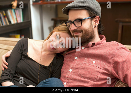 Paar auf Sofa sitzen, Arm um Stockfoto