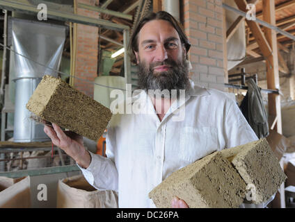 Rainer Nowotny, Geschäftsführer der Firma Hanffasern präsentiert Uckermark z. B. Ziegel hergestellt aus Lehm und Hanf in Prenzlau, Deutschland, 24. Juli 2013. 13 Mitarbeiter verarbeiten Hanf von etwa 300 Hektar Anbaufläche für den Aufbau und Isoliermaterial in der Firma. Foto: Bernd Settnik Stockfoto