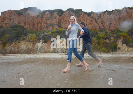 Älteres Paar am Strand laufen Stockfoto