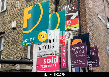 Wettbewerb auf dem Immobilienmarkt. Eine große Reihe von Immobilienmakler für Verkauf und Vermietung Zeichen erscheinen auf einer Eigenschaft in einer Straße nahe Clapham Junction, London, UK, 7. August 2013. Stockfoto