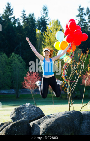 Teenager-Mädchen mit Luftballons, die Luft zu springen Stockfoto