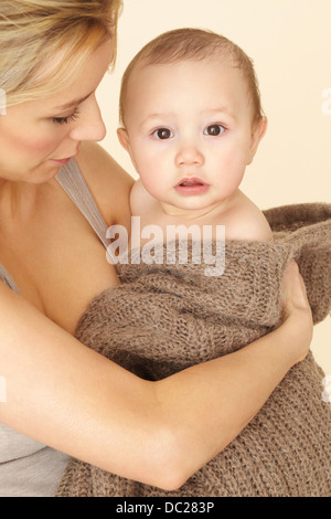 Mutter mit Baby Sohn eingewickelt in Strick Stockfoto