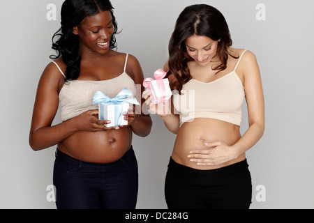 Zwei schwangere Frauen mit rosa und blauen Geschenkboxen