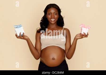 Schwangere junge Frau mit blau und Rosa Geschenk-Boxen Stockfoto