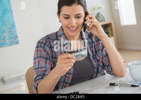 Junge Frau am Handy mit Kreditkarte Stockfoto