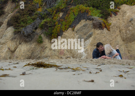 Älteres Paar am Strand von Felsen liegen Stockfoto
