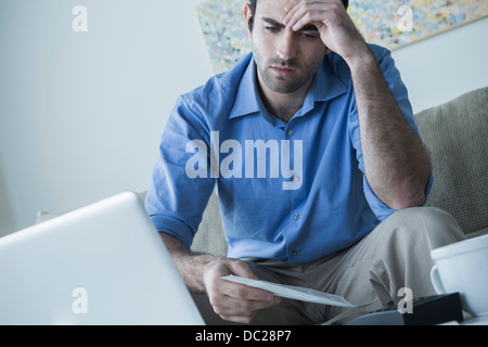 Besorgt Man mit Hand am Kopf halten Rechnungen Stockfoto