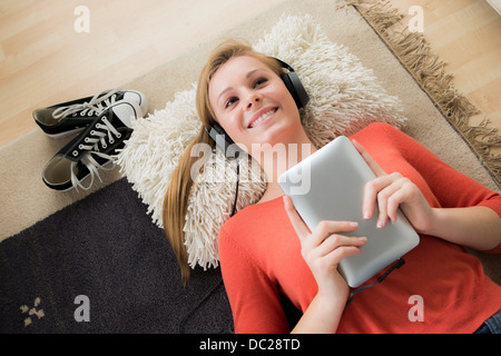 Teenager-Mädchen mit Kopfhörern mit digital-Tablette Stockfoto