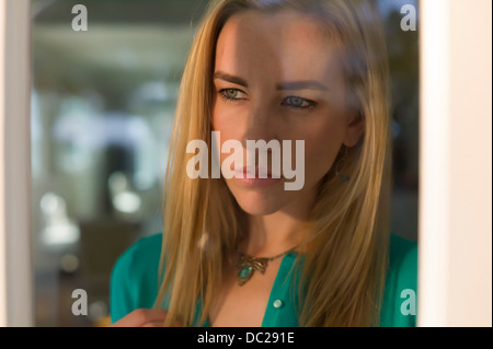 Porträt der jungen Frau aus Fenster Stockfoto