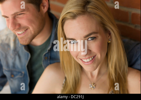 Porträt des Paares, lächelnde junge Frau im Mittelpunkt Stockfoto