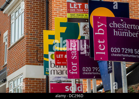 Wettbewerb auf dem Immobilienmarkt. Eine große Reihe von Immobilienmakler für Verkauf und Vermietung Zeichen erscheinen auf einer Eigenschaft in einer Straße nahe Clapham Junction, London, UK, 7. August 2013. Stockfoto