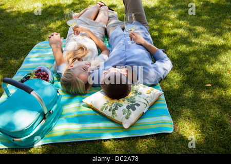 Junges Paar auf der Picknickdecke liegen Stockfoto