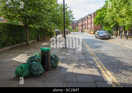 Müll Taschen voller Wurf von bin warten gesammelt werden. Castlefield, Manchester. Stockfoto