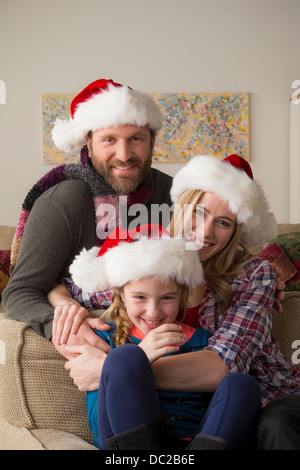 Eltern und Kind in Nikolausmütze posiert für die Kamera Stockfoto