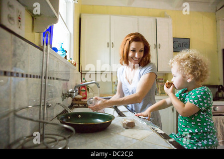 Mutter am Waschbecken Kind lächelt Stockfoto