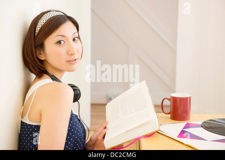 Frau aus Buch nachschlagen Stockfoto