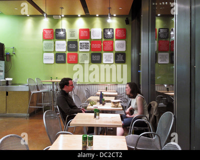 nettes junges Paar sitzen über Salate im modernen Interieur Gesundheit bewusste Fastfood-Restaurant in Nähe Times Square Manhattan Stockfoto
