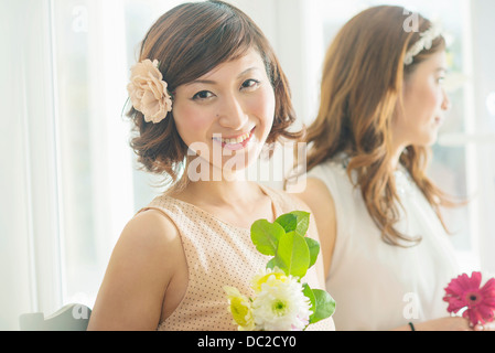 Lächelnde Frau mit Blume Blick in die Kamera Stockfoto