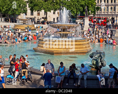 Blick auf Brunnen am Trafalgar Square an einem sonnigen Tag mit Massen von Menschen Stockfoto