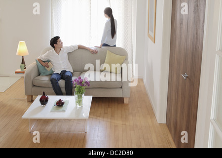 Mann sich wendend Runde auf Sofa Frau anschauen Stockfoto